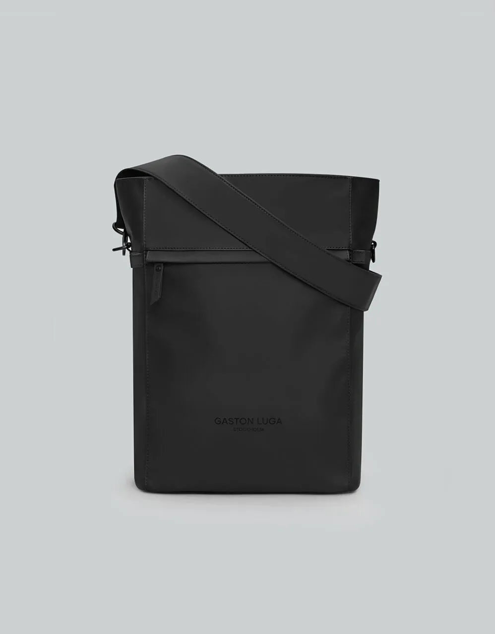 Mochila Täte negra, vista frontal con bolsillo con cierre y correa de hombro