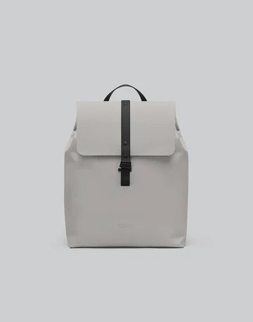 Mochila Däsh Bucket taupe, vista frontal con solapa y correa central negra
