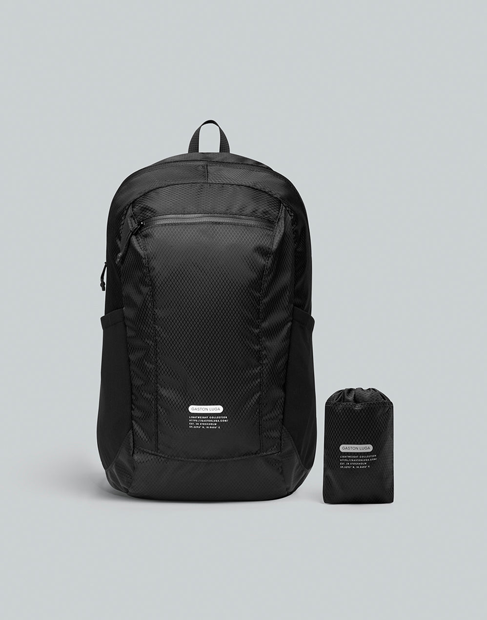 Mochila Lightweight Packable negra vista de frente, junto a su bolsa compacta de almacenamiento.