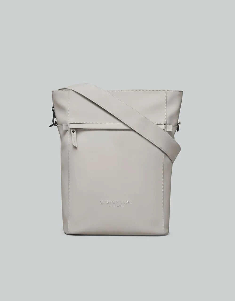 Mochila Täte taupe, vista frontal con bolsillo con cierre y correa de hombro